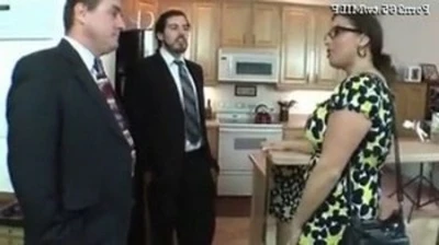 man and woman intimate in kitchen with additional person nearby