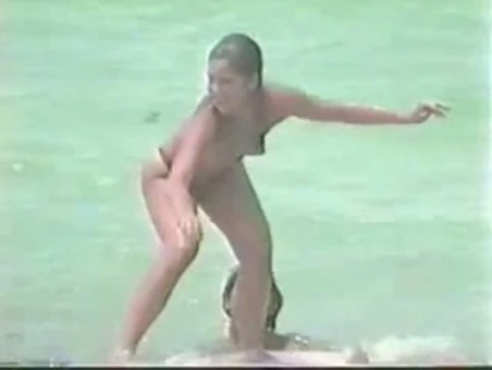 nude woman surfing, aggressively riding waves in miami